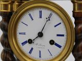 a gold clock with blue roman numerals on it