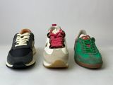 three pairs of sneakers are lined up in a row on a white surface