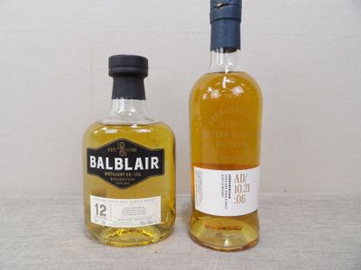 deux bouteilles d'alcool posées l'une à côté de l'autre sur une table