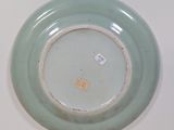 a green plate with a tag on it sitting on a table