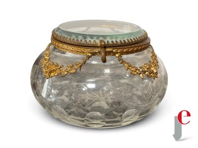 a glass jar with a lid that has a gold decoration on it