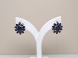 pair of blue and white flower earrings on a white stand