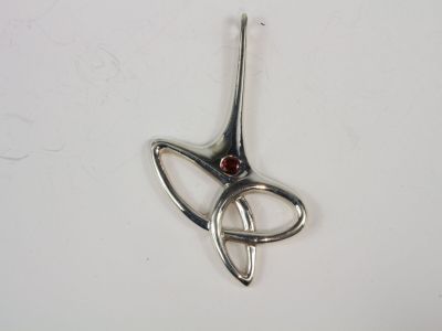 silver plated pendant with a red stone in the shape of a bird