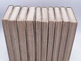 several books stacked on top of each other on a white surface