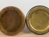pair of antique brass and copper plate holders on a table