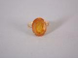 a close up of a ring with an orange stone on it