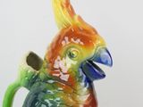 a colorful bird that is sitting on top of a cup