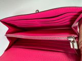 someone is holding a pink purse that has a zipper on it