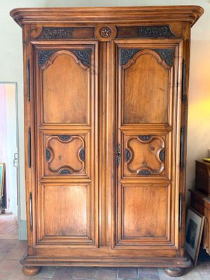 une grande armoire en bois dans une pièce au sol carrelé