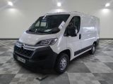la camionnette blanche est garée dans une grande pièce au sol en damier