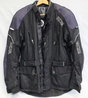 une veste de moto noire et violette suspendue à un cintre sur fond blanc