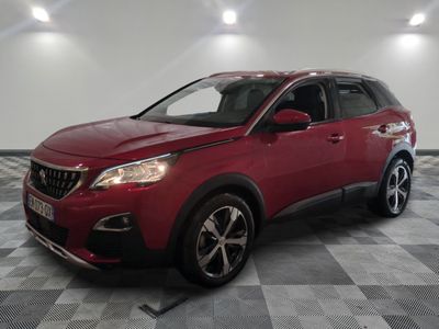une voiture rouge est garée dans une pièce au sol en damier