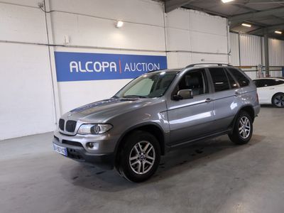 a silver bmw suv parked in a garage