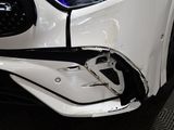 the front of a white car with a denting bumper