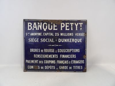 une enseigne bleue et blanche sur un mur blanc, sur laquelle on peut lire « Banque Petity »
