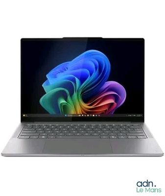 un gros plan d'un ordinateur portable posé sur une surface blanche, avec un arrière-plan coloré