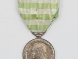 une image représentant une médaille entourée d'un ruban et sur laquelle figure une pièce de monnaie