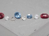 quatre pierres précieuses de couleurs différentes sont disposées en ligne sur une surface grise