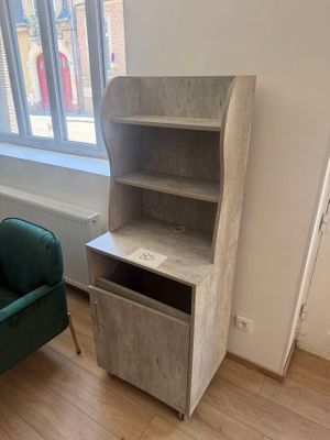 a green chair in the corner of a room next to a book shelf