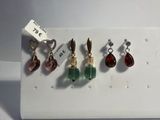 Trois paires de boucles d'oreilles sont disposées sur un plateau blanc