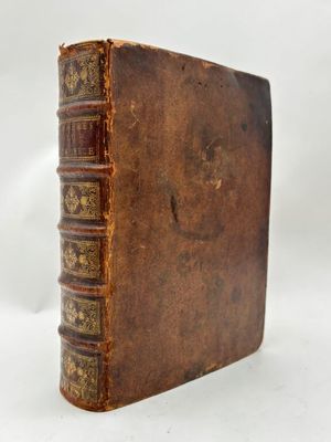 un vieux livre posé sur une table blanche devant un fond blanc
