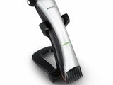 La tondeuse à cheveux Philips est posée sur un support, sur une surface blanche.