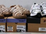 several pairs of shoes are stacked on top of boxes on a table
