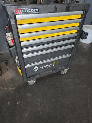 La boîte à outils est posée par terre dans le garage.