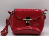 the red purse is sitting on a white surface