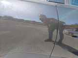 a reflection of a man on the side of a car door