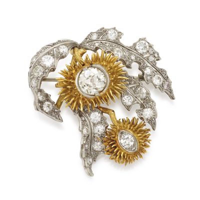 a close up of a brooch with flowers and leaves on a white background
