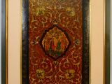 tableau encadré représentant un homme et une femme sur un fond rouge et or