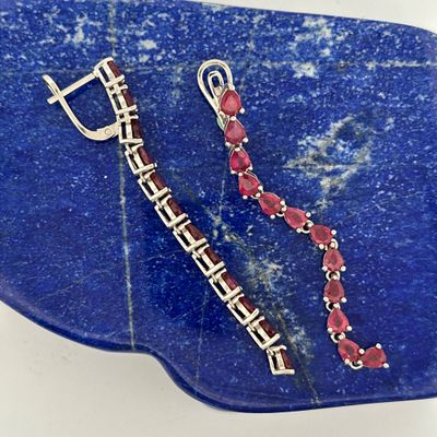 sterling silver and red garnett earrings on a blue stone