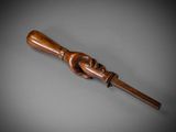 an old wooden stick with a wooden handle on a gray surface