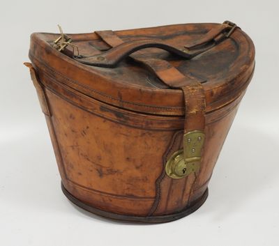 an old wooden box with a leather handle on a white surface