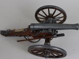 a toy cannon sitting on top of a wooden wheel