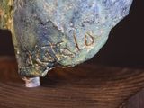 a close up of a statue of a bird on a wooden base