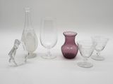 a lot of wine glasses and vases sitting on a table