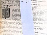 un morceau de papier collé à un livre, sur lequel figure l'image d'un blason