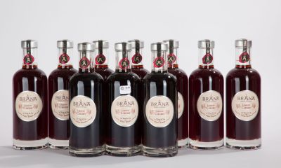 six bouteilles de vin sont alignées sur une surface blanche
