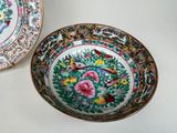 two plates with flowers and birds on them on a table