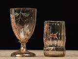 two wine glasses sitting on a table with a black background