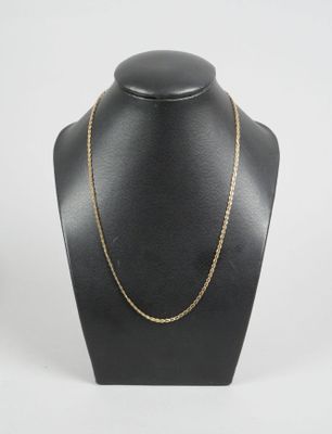 a black mannequin with a gold chain on it