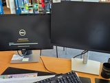 un écran d'ordinateur et un clavier posés sur un bureau dans une bibliothèque