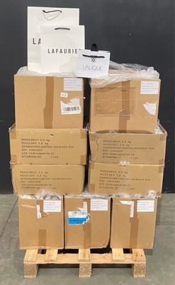 des cartons empilés sur une palette devant un mur noir