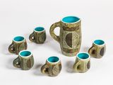 five cups and a pitcher in the middle of a circle