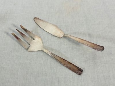 two forks and spoons are sitting on a table cloth