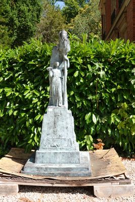 une statue de femme tenant un enfant sur un piédestal