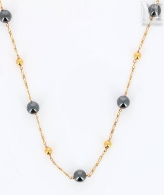 a black and gold beaded necklace on a gold chain