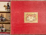 a red box with figurines in it on a table